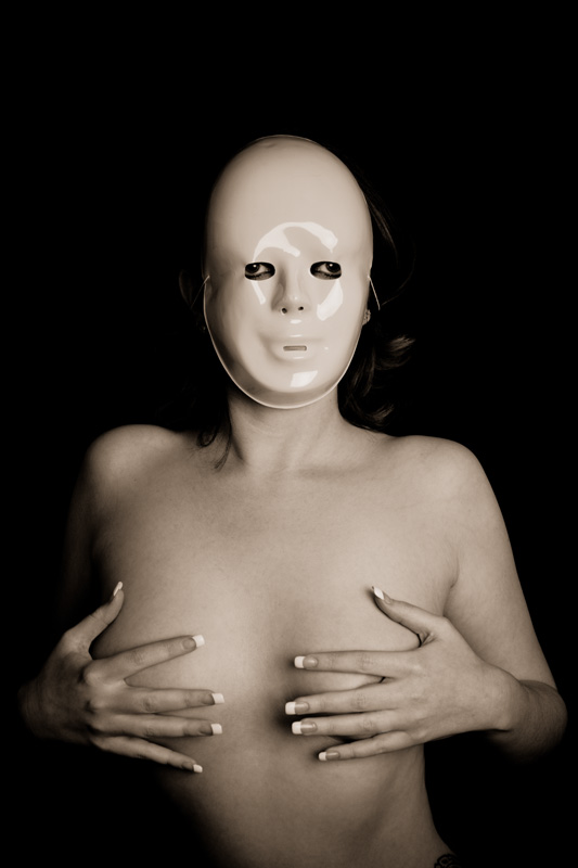 Nude girl in mask covering her breasts